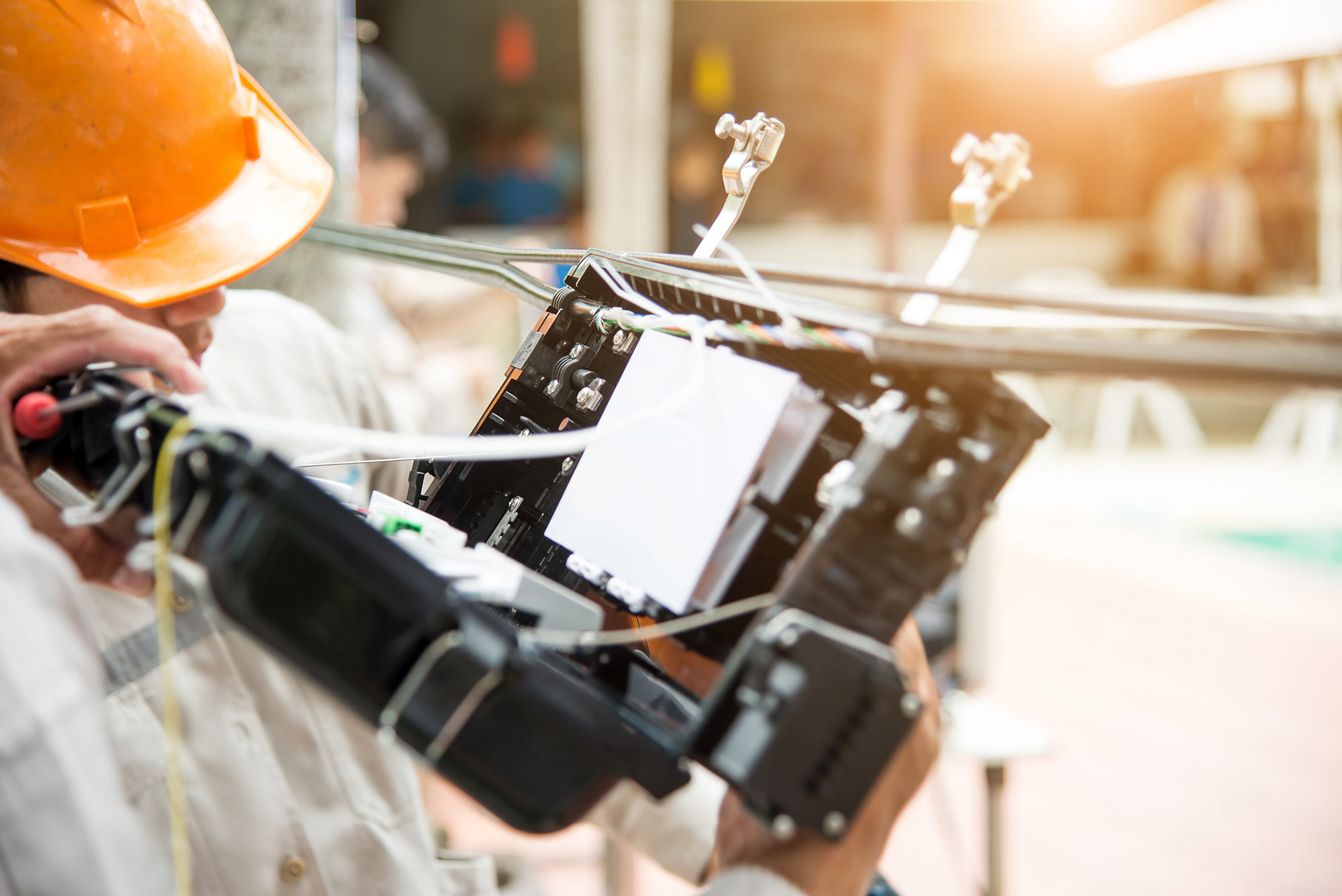 Telecom technician installing cable in overhead fiber pathways